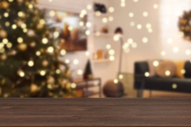 Boş ahşap masa, bulanık odaya karşı, Noel ağacı ve ışık var. Tasarım için boşluk
