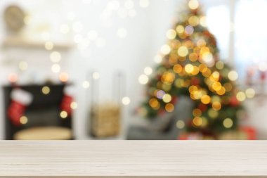 Boş ahşap masa, bulanık odaya karşı, Noel ağacı ve ışık var. Tasarım için boşluk