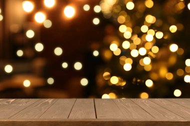 Boş ahşap masa, bulanık odaya karşı, Noel ağacı ve ışık var. Tasarım için boşluk