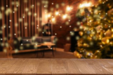 Boş ahşap masa, bulanık odaya karşı, Noel ağacı ve ışık var. Tasarım için boşluk