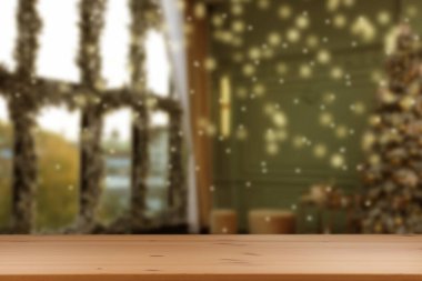 Boş ahşap masa, bulanık odaya karşı, Noel ağacı ve ışık var. Tasarım için boşluk