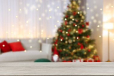 Boş ahşap masa, bulanık odaya karşı, Noel ağacı ve ışık var. Tasarım için boşluk