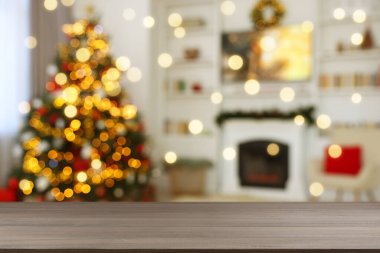 Boş ahşap masa, bulanık odaya karşı, Noel ağacı ve ışık var. Tasarım için boşluk