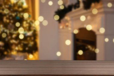 Boş ahşap masa, bulanık odaya karşı, Noel ağacı ve ışık var. Tasarım için boşluk