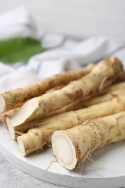 Açık gri masada taze çiğ yaban turpu kökleri, yakın plan.