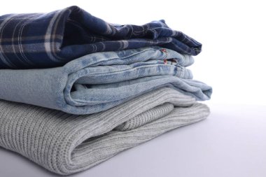 Beyaz arka planda katlanmış temiz giysi yığını, yakın plan