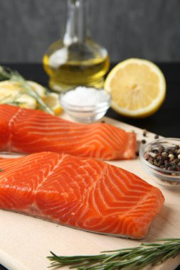 Somon fileto, baharat, limon ve yağ parçaları masada, yakın plan.