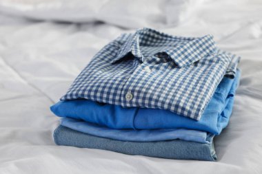 İçerideki yatağın üzerine temiz giysiler yığılır, yakın plan.