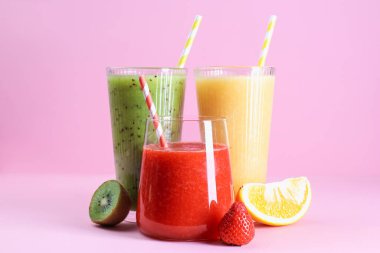 Farklı lezzetli içecekler, pembe arka planda bardaklar ve malzemeler.