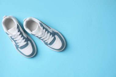 Açık mavi arka planda şık bir çocuk ayakkabısı, düz yatıyordu. Metin için boşluk