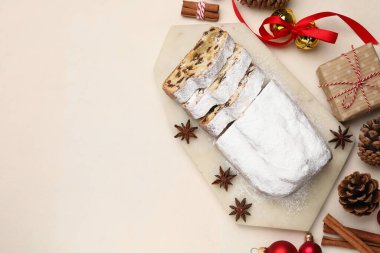 Geleneksel Stollen pastasını, hediyesini ve Noel dekorunu beyaz masaya koyun. Metin için boşluk