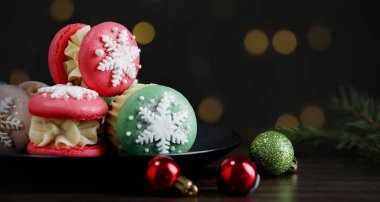 Kurabiyeler ve siyah ahşap masada bulanık ışıklara karşı Noel süsü, yakın plan. Metin için boşluk