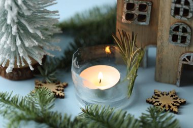 DIY feneri. Yanan buz mumu ve açık mavi arka planda Noel dekoru, yakın plan