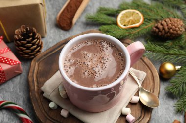 Lezzetli kakao, marşmelov ve Noel dekoru gri masada, yakın plan.