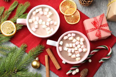 Marşmelovlu, tarçınlı ve gri masada Noel dekorlu lezzetli kakao.