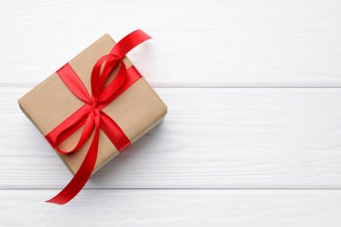Beyaz ahşap arka planda güzel bir hediye kutusu, üst manzara. Metin için boşluk
