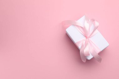 Pembe arka planda güzel bir hediye kutusu, üst manzara. Metin için boşluk