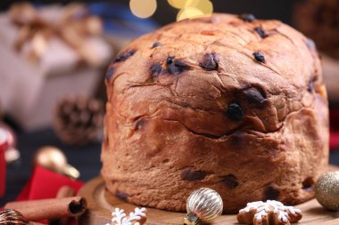 Noel yemeği. Lezzetli Panettone keki, zencefilli kurabiye ve bulanık ışıklara karşı masanın üstünde dekor, yakın plan. Bokeh etkisi