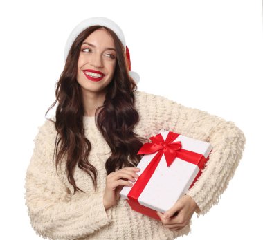 Güzel kadın Noel Baba şapkası takıyor ve beyaz arka planda Noel hediyesi var.