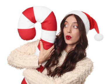 Beyaz arka planda Noel Baba şapkalı ve baston şekerli yastıklı güzel bir kadın. Noel sezonu