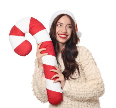 Beyaz arka planda Noel Baba şapkalı ve baston şekerli yastıklı güzel bir kadın. Noel sezonu