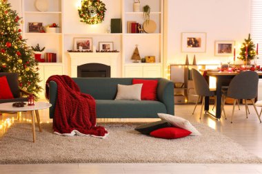 Noel ağacı, kanepe, şömine ve şenlikli dekorlu şık bir oda. İç tasarım