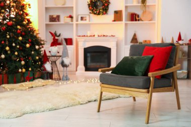 Şömine, koltuk, Noel ağacı ve şık odada şenlikli bir dekor.