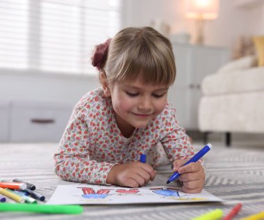 Evinde keçeli kalemle çizen sevimli küçük kız.