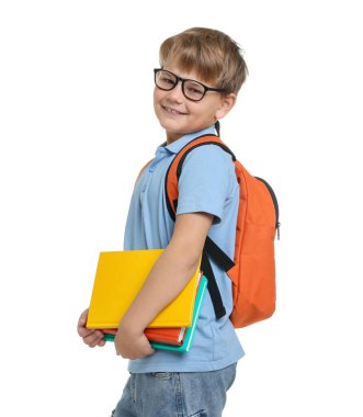 Beyaz arka planda kitapları ve sırt çantası olan sevimli bir çocuk.