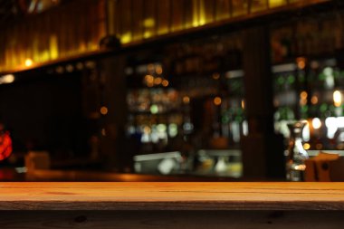 Bardaki boş ahşap masa, bulanık arka plan. Tasarım için boşluk