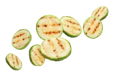 Izgara kabak parçaları beyaz arka planda havada uçuşuyor.