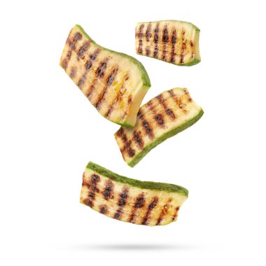 Izgara kabak parçaları beyaz arka plana düşüyor.