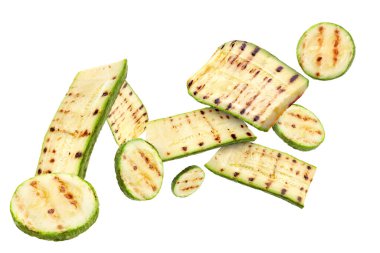 Izgara kabak parçaları beyaz arka planda havada uçuşuyor.