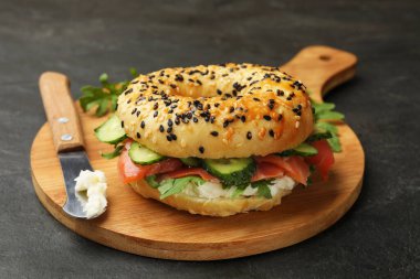 Somon, krem peynir, salatalık ve roka siyah masada, yakın plan.