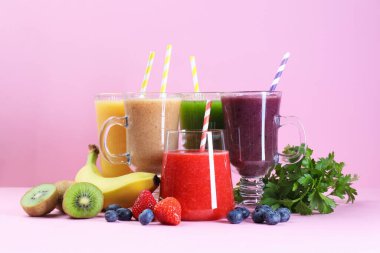 Farklı lezzetli içecekler, pembe arka planda bardaklar ve malzemeler.