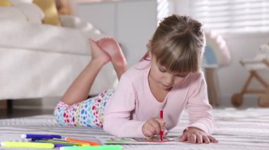 Evinde keçeli kalemle resim yapan sevimli küçük kız, kamera hareket ediyor.