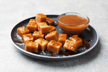 Gri desenli masada tuzlu ve karamel soslu lezzetli şekerler, yakın plan.