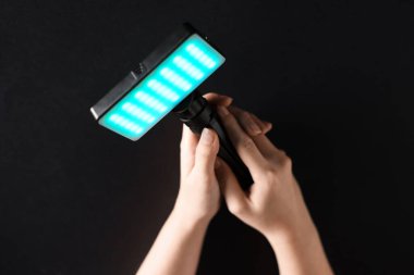 Siyah arka planda parlayan LED lambalı kadın, yakın plan