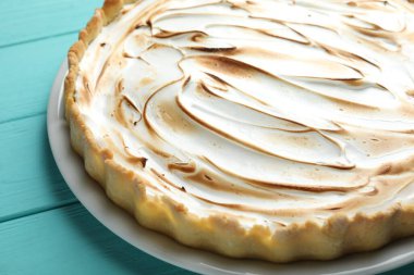 Turkuaz ahşap masada lezzetli limonlu turta, yakın plan.