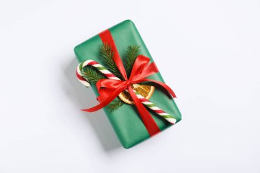 Beyaz arka planda baston şekerle süslenmiş Noel hediyesi.