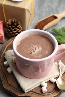 Lezzetli kakao, marşmelov ve Noel dekoru gri masada, yakın plan.