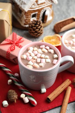 Gri masada marşmelovlu, tarçınlı ve Noel dekorlu lezzetli kakao, yakın plan.
