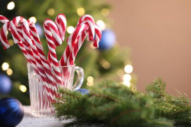 Bardaktaki şeker kamışları ve masadaki bulanık ışıklara karşı Noel süsü. Metin için boşluk