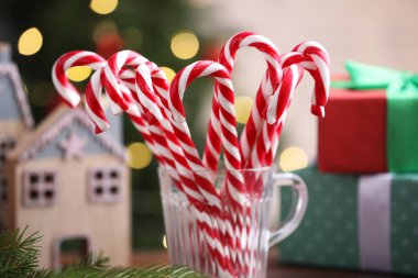 Bardakta şeker kamışı ve masada bulanık ışıklara karşı Noel dekoru, yakın çekim