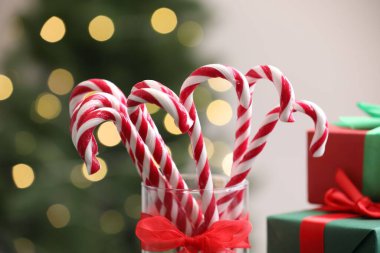 Bardaktaki şeker çubukları bulanık ışıklara karşı, yakın plan. Noel hediyesi