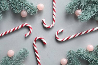 Şeker kamışları ve açık gri arka planda Noel dekoru, düz yatış