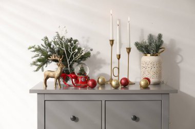 Beyaz duvarın yanındaki gri dolapta farklı bir Noel dekoru var.