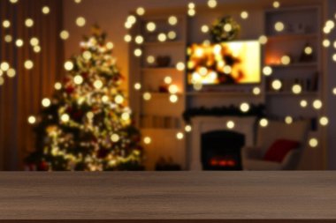 Boş ahşap masa, bulanık odaya karşı, Noel ağacı ve ışık var. Tasarım için boşluk