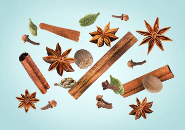 Açık mavi arka planda düşen Noel baharatları