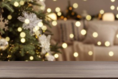 Boş ahşap masa, bulanık odaya karşı, Noel ağacı ve ışık var. Tasarım için boşluk